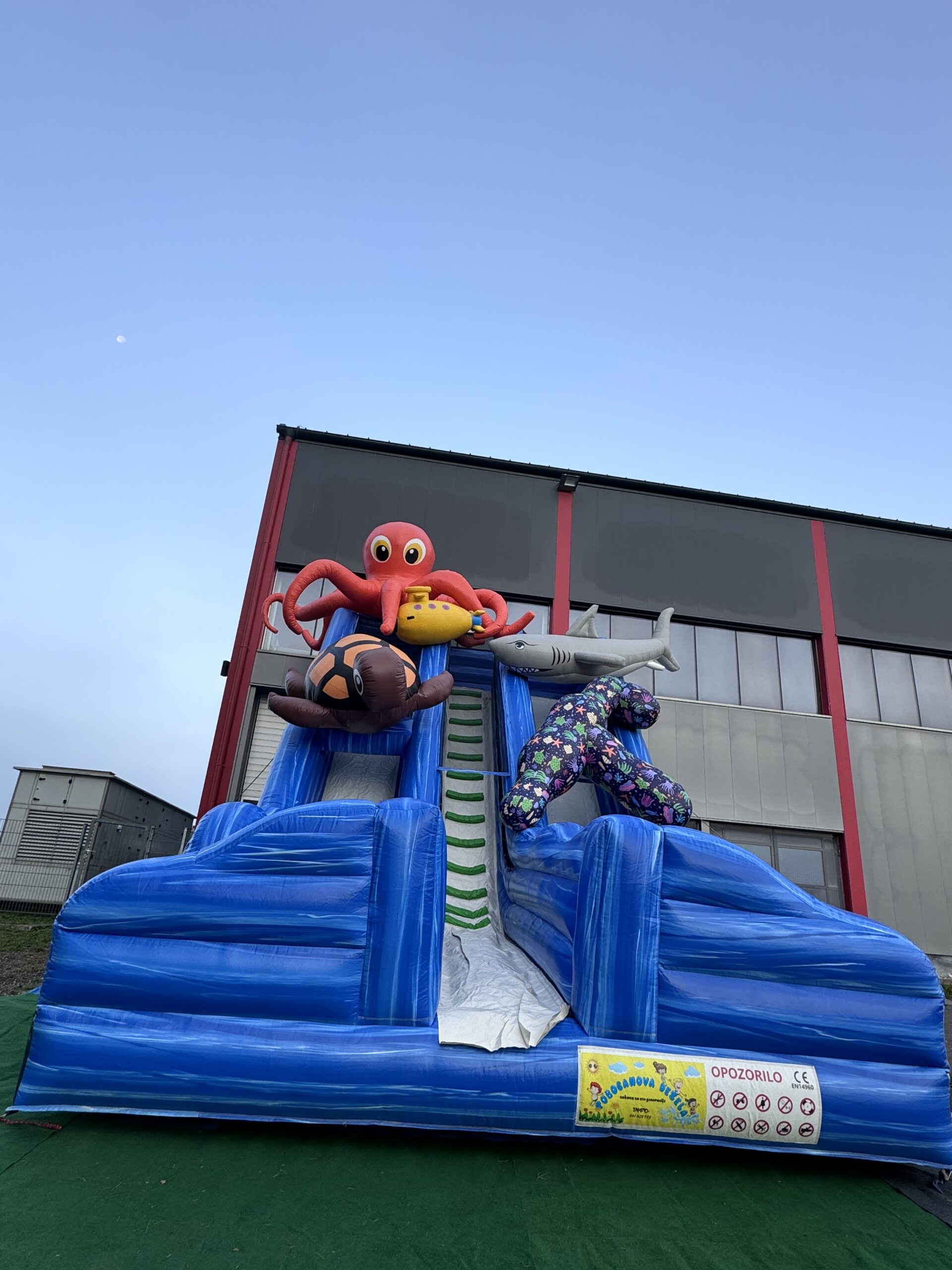 Veliko napihljivo igralo z motivom morskega sveta – idealno za poletne otroške zabave z delfini, ribicami in toboganom.
